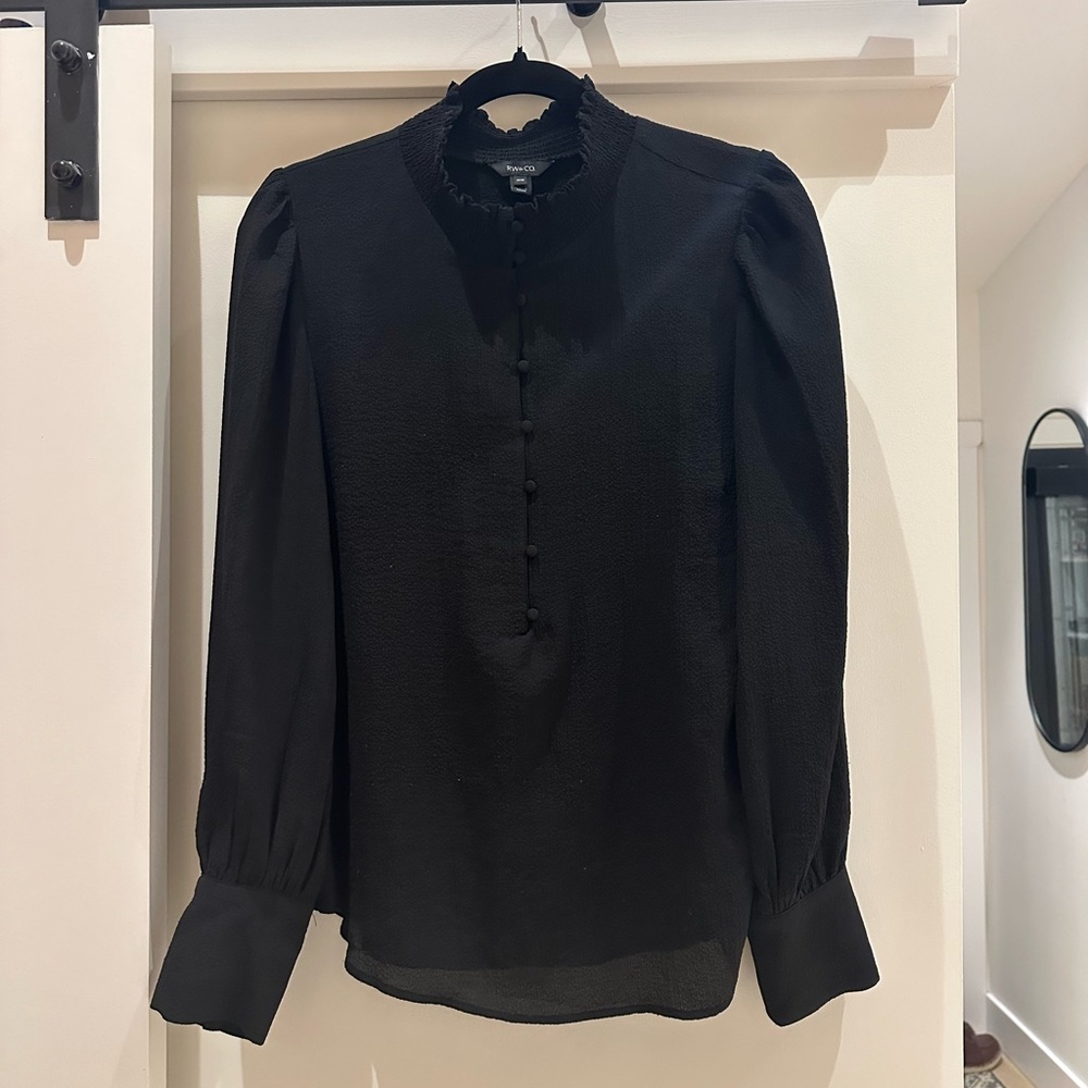 Size M. Black long sleeved blouse with cute detail on shoulders and cuff.